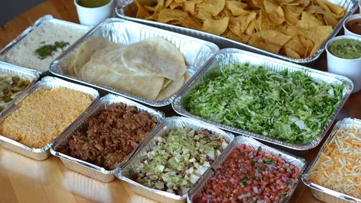 Inclusive corporate lunch buffet with mixed proteins, vegan options, and clearly separated toppings
