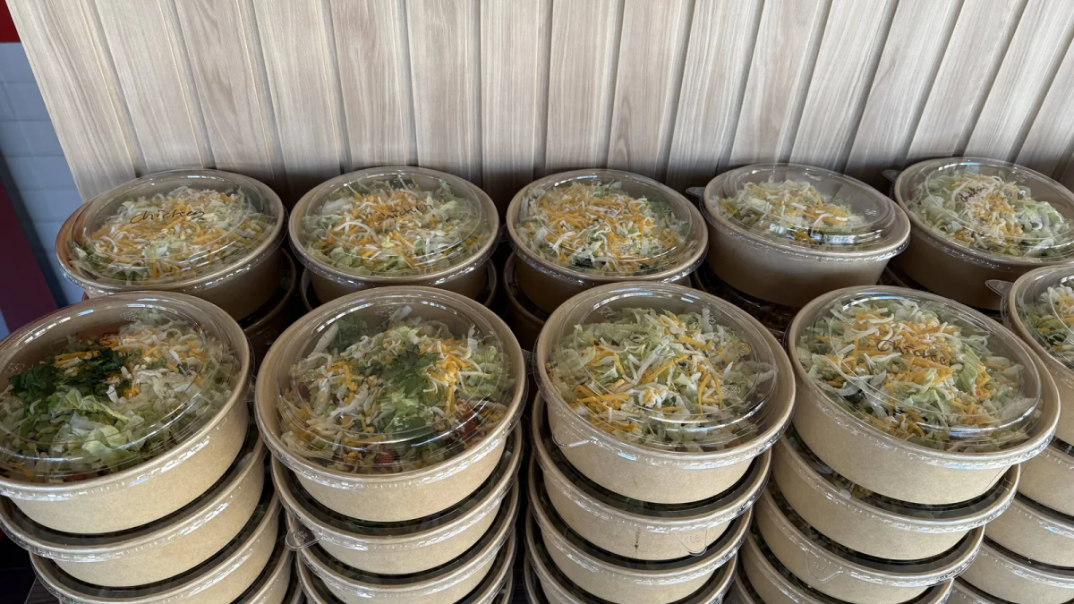 Clearly labelled packaged burrito bowls arranged for a hybrid office lunch